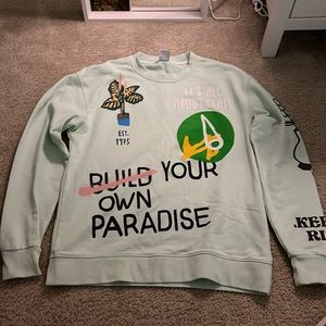 Never worn, teal sweater with graphic print.